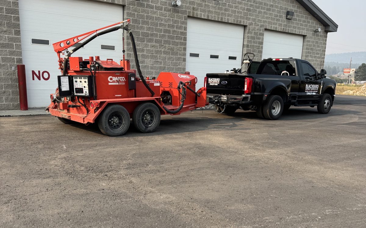 Blackbird Asphalt Services truck towing a Crafco hot-pour crack sealing unit
